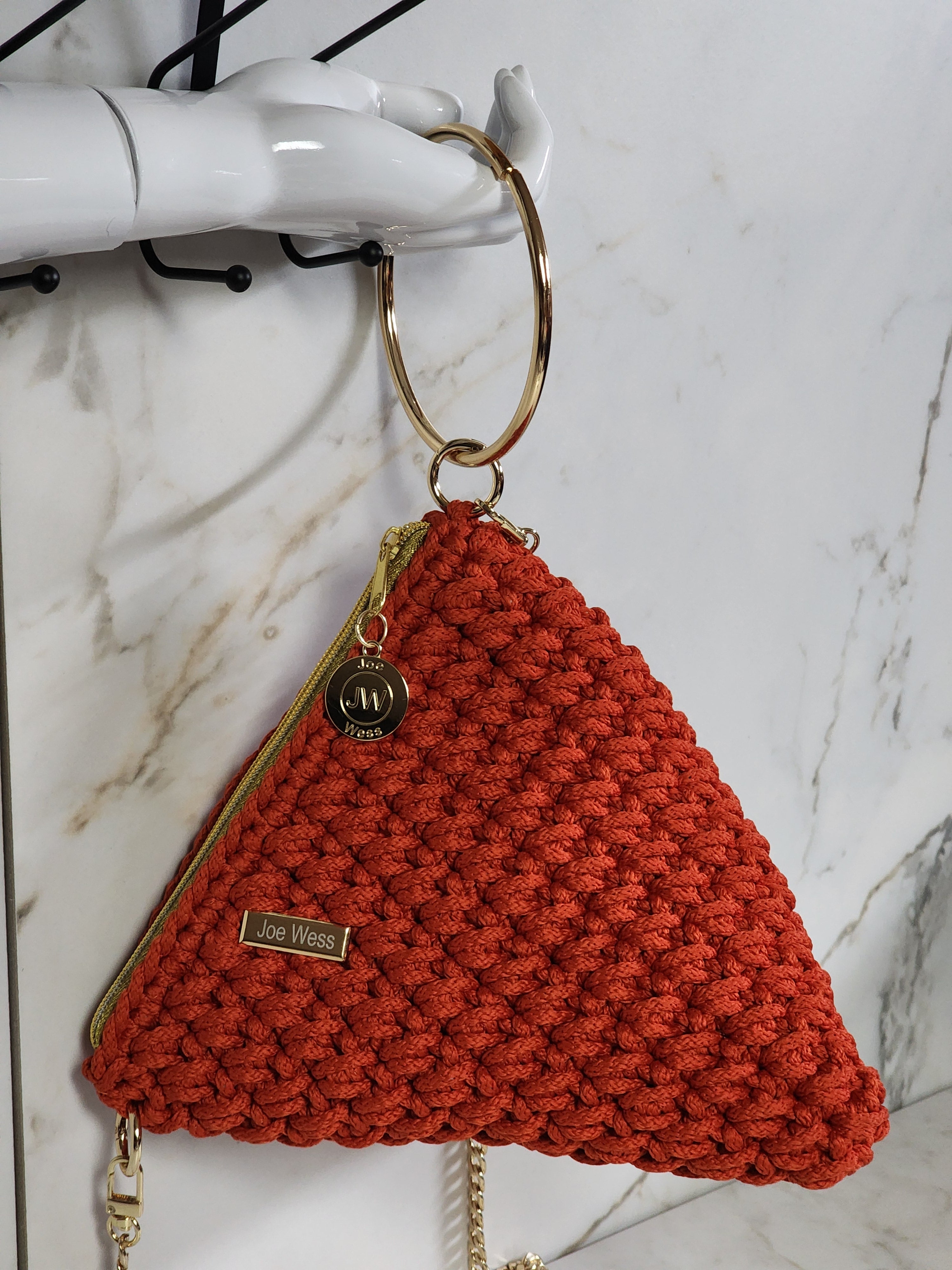 Handcrafted orange crochet purse with intricate detailing, a warm vibrant tone, and a refined, elegant silhouette.