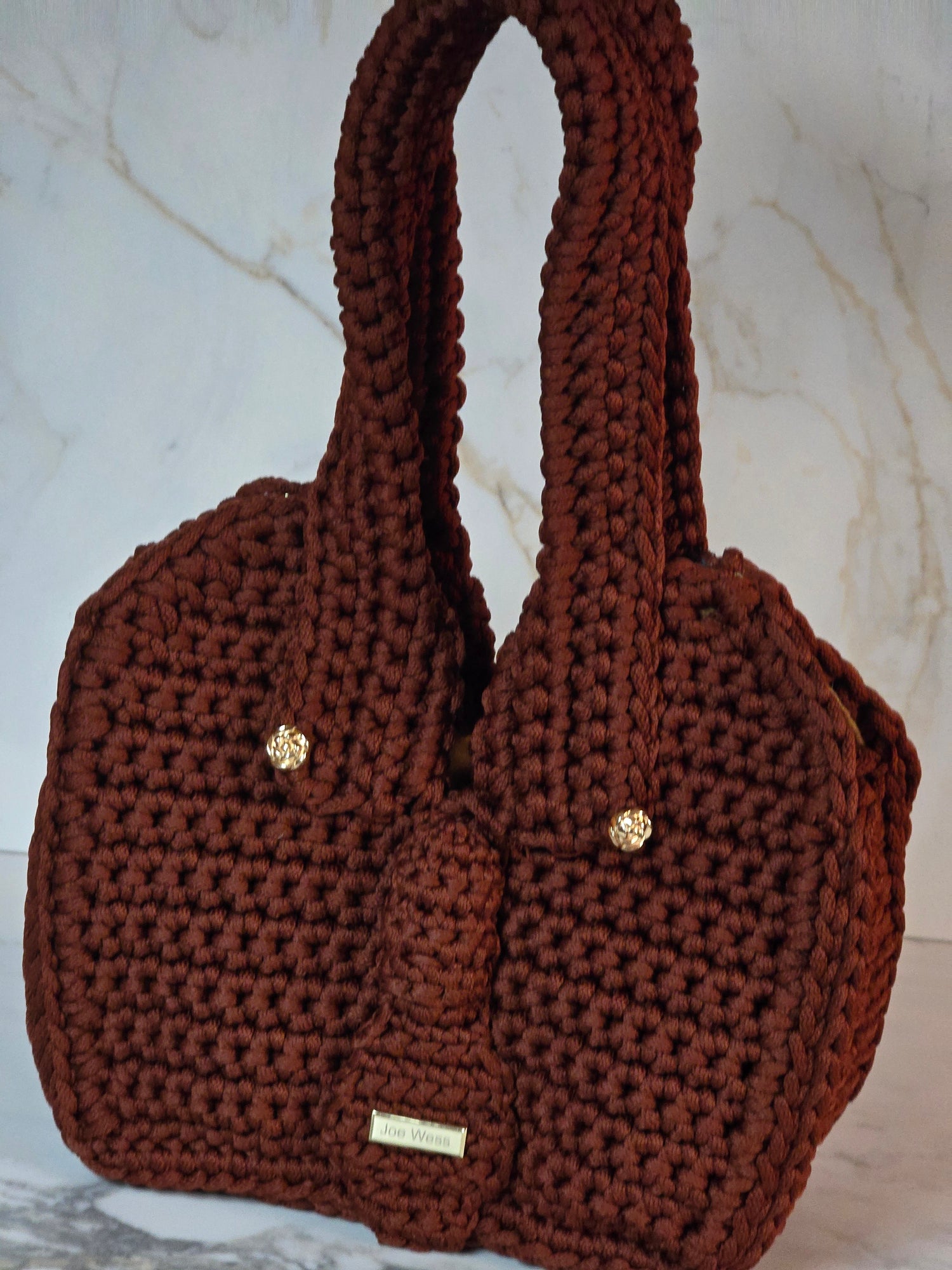 Burgundy handcrafted crochet purse with textured stitching and a chic, contemporary shape.
